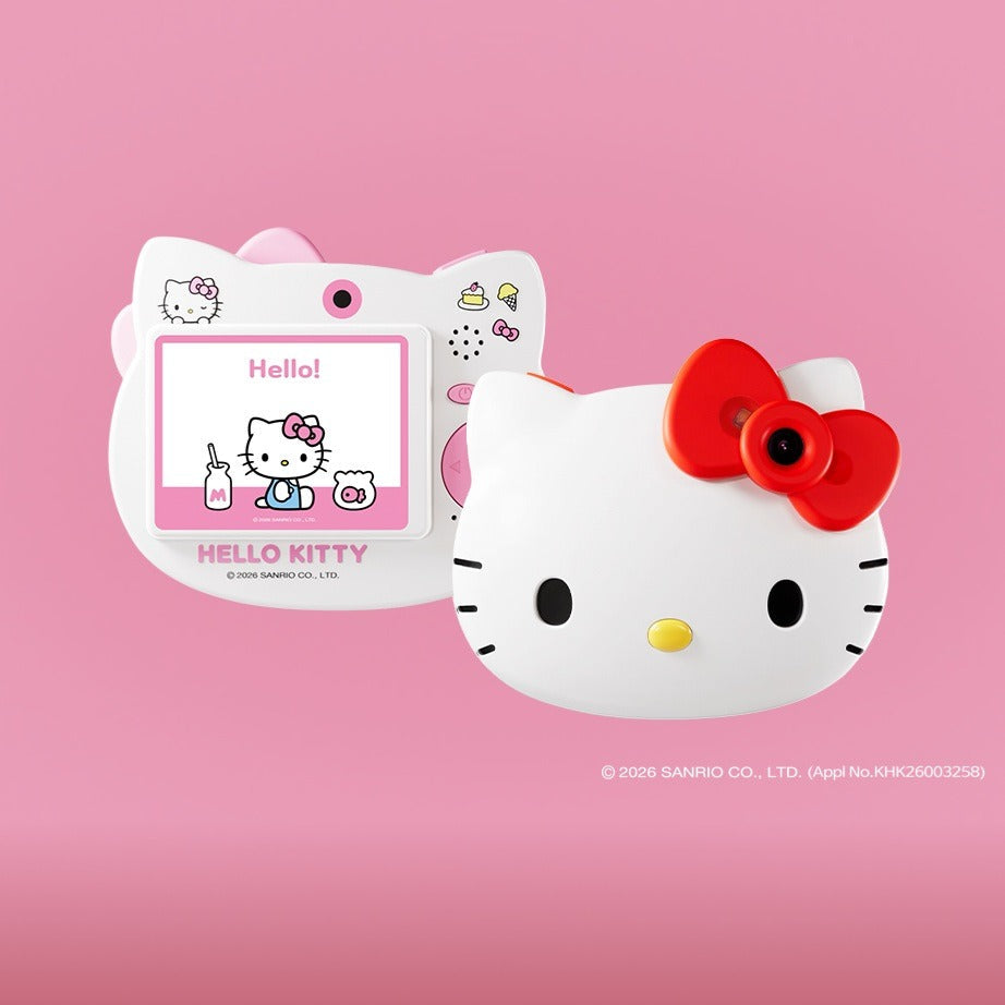 Hello Kitty themed electronic toy camera featuring a white cat face with a red bow and a small screen display, set against a pink gradient background.